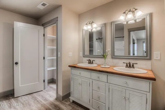 a bathroom with double vanity sinks and a mirror