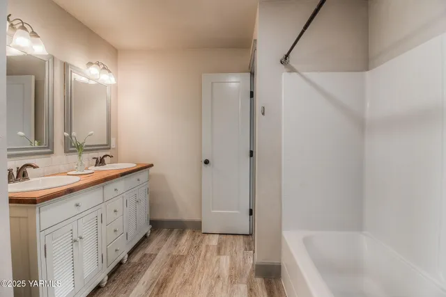 a bathroom with a tub sink and mirror