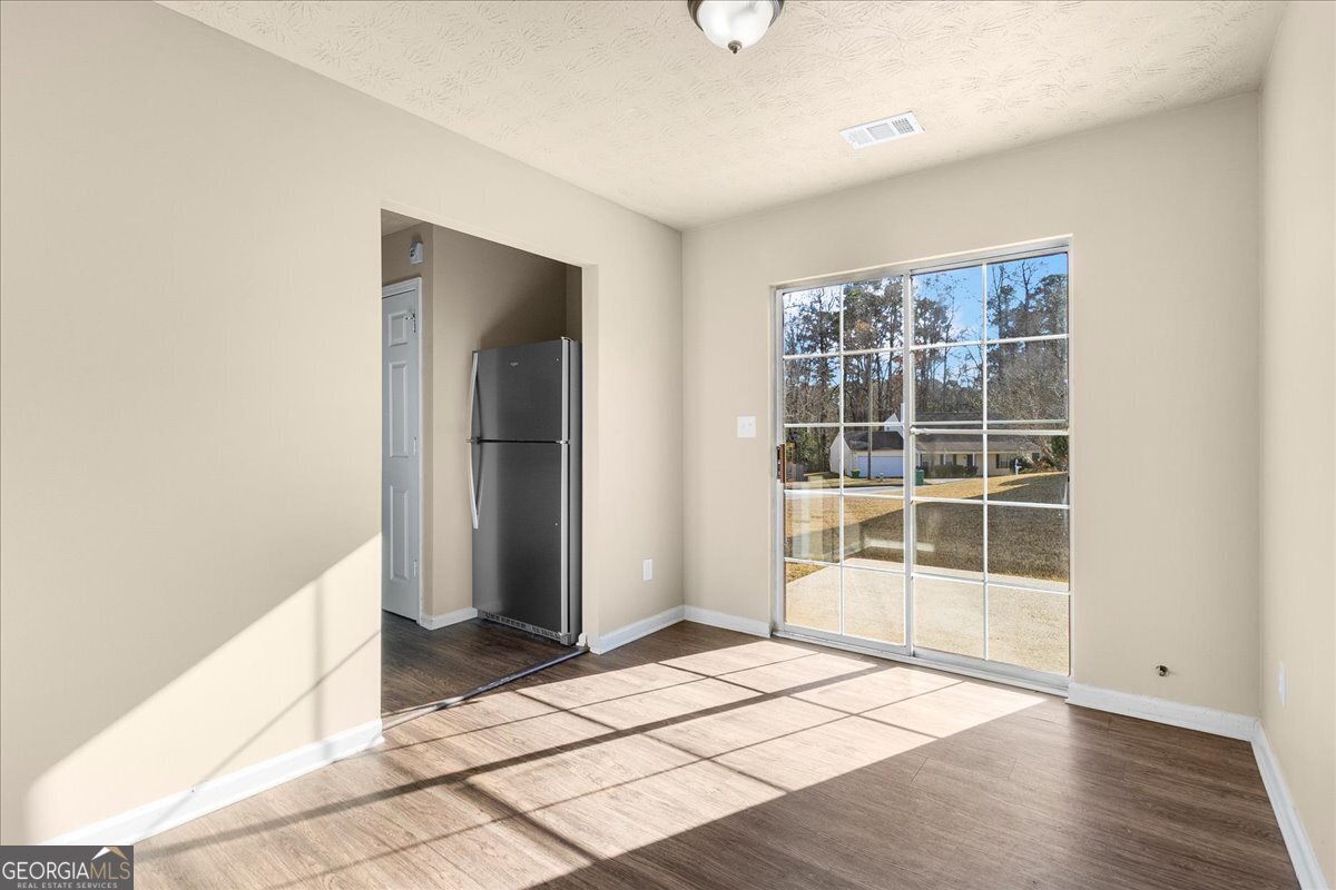 2603 Old Rex Morrow Road Ellenwood, GA 30294 - Photo 11 of 32 an empty room with wooden floor and windows