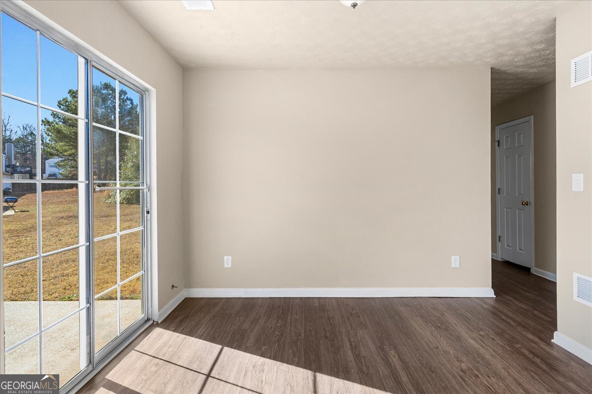 2603 Old Rex Morrow Road Ellenwood, GA 30294 - Photo 12 of 32 an empty room with wooden floor and windows