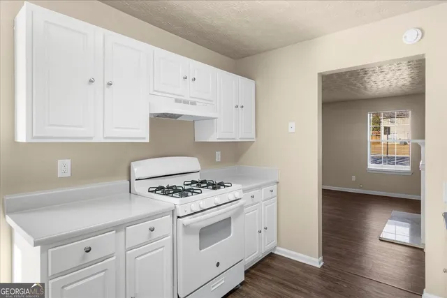 a kitchen with white cabinets and white appliances