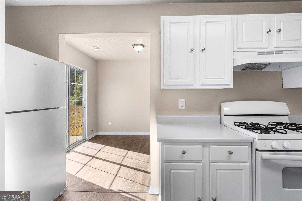 2603 Old Rex Morrow Road Ellenwood, GA 30294 - Photo 16 of 32 a kitchen with white cabinets and white appliances