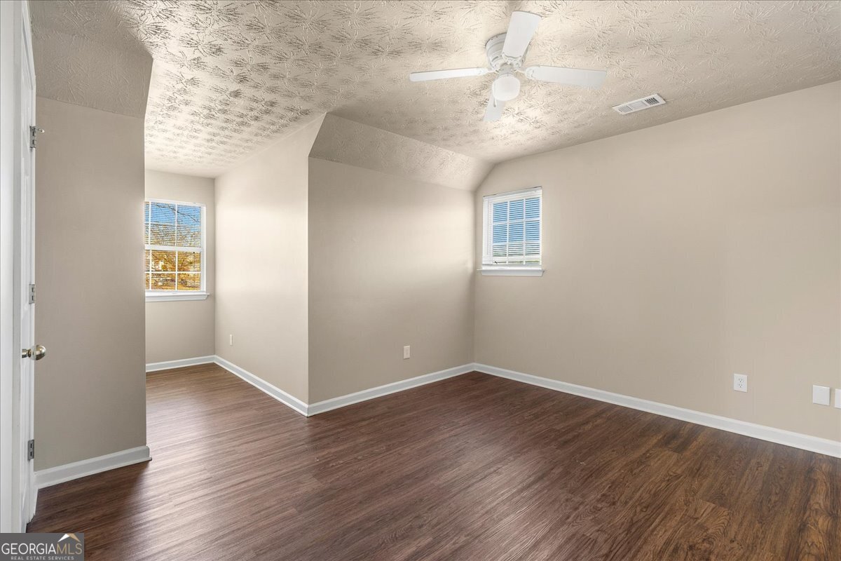 2603 Old Rex Morrow Road Ellenwood, GA 30294 - Photo 25 of 32 an empty room with wooden floor and windows