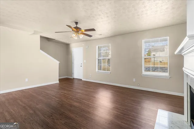 a view of a livingroom with wooden floor and a ceiling fan