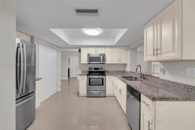 a kitchen with stainless steel appliances granite countertop a refrigerator stove and sink
