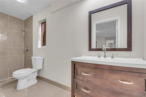 a bathroom with a toilet sink and mirror