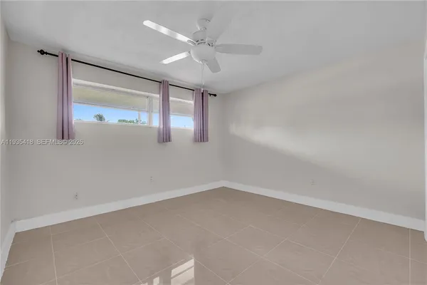 an empty room with a ceiling fan and a window