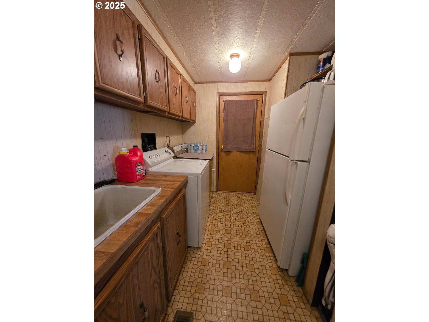358 Oak Park Place Wamic, OR 97063 - Photo 24 of 29 a kitchen with a sink a refrigerator and cabinets