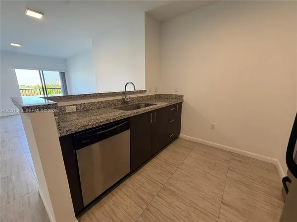a kitchen with granite countertop a sink and a wooden floor