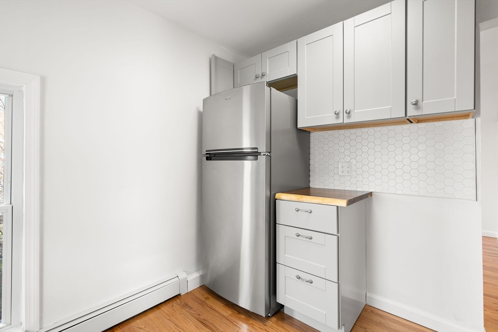 19 Berkley Road Hull, MA 02045 - Photo 30 of 42 a kitchen with white cabinets and refrigerator