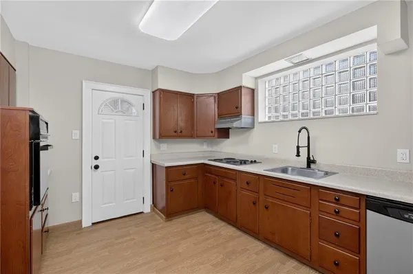 a kitchen with stainless steel appliances granite countertop a sink and a refrigerator