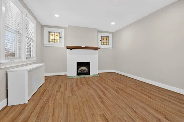 a view of empty room with wooden floor and fireplace