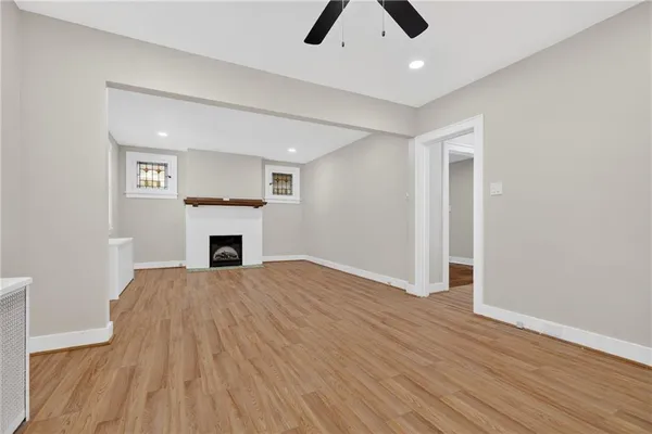 a view of empty room with wooden floor and fireplace
