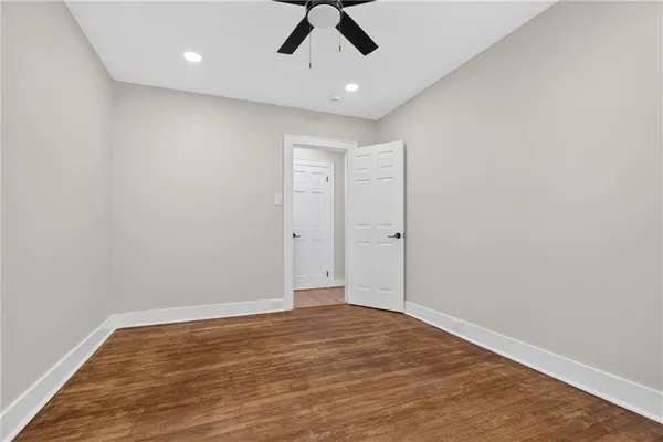 an empty room with a ceiling fan and carpet