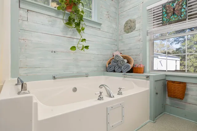 a bathroom with a tub sink and mirror