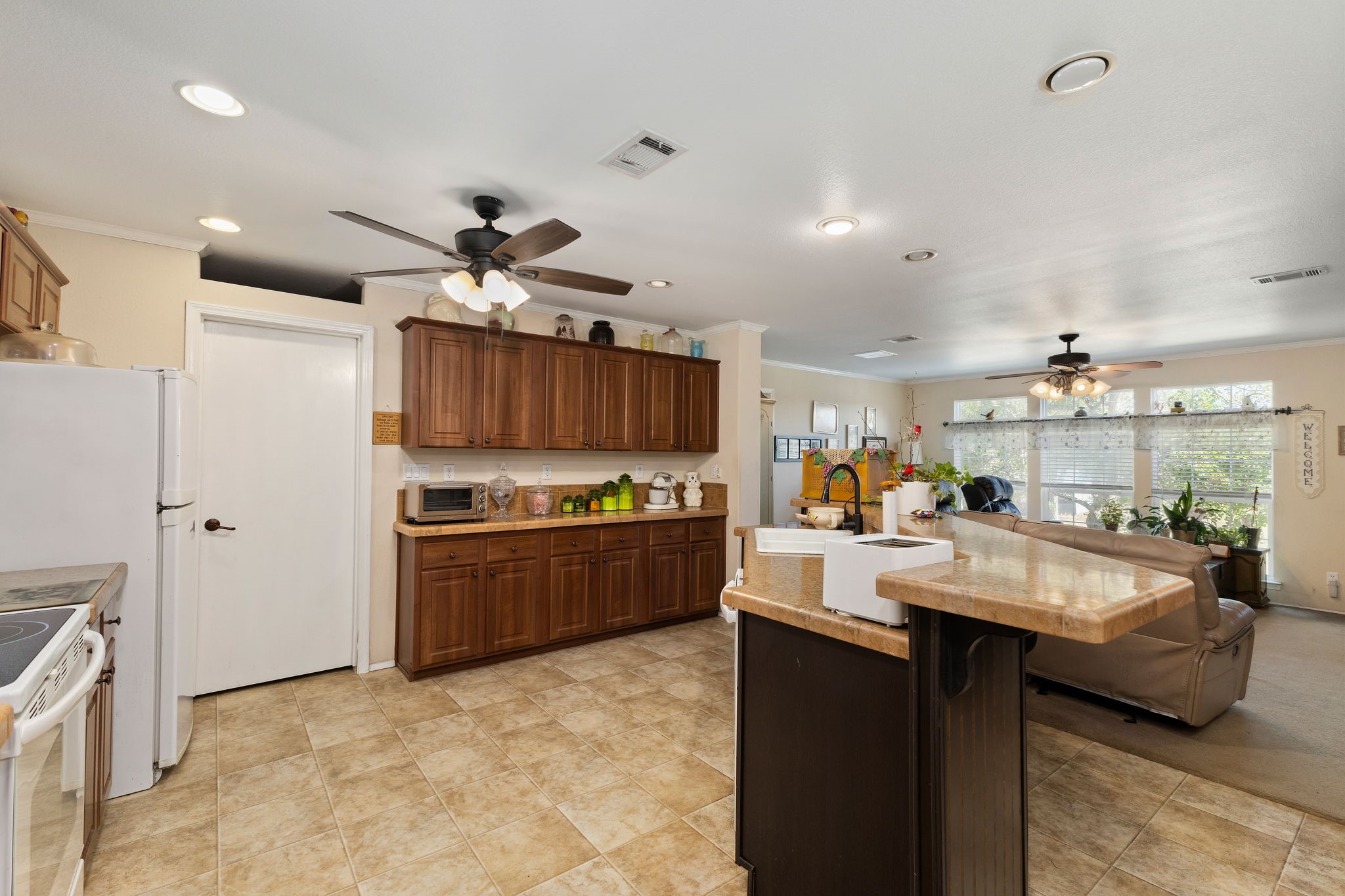 8103 Adamek Road Brenham, TX 77833 - Photo 20 of 42 a large kitchen with kitchen island a large counter space a sink appliances and cabinets