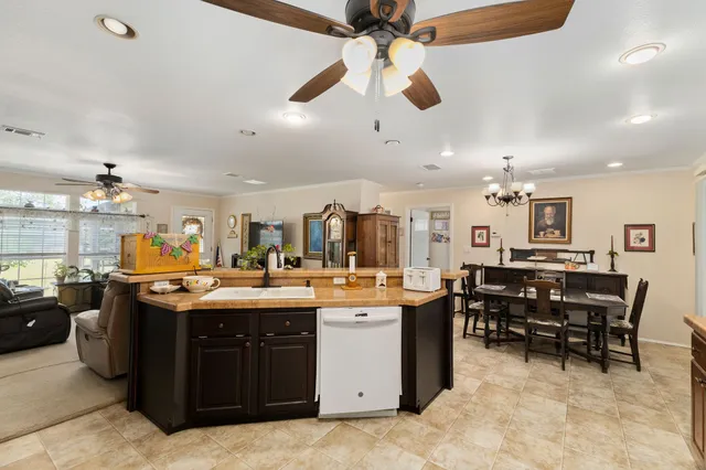 a large kitchen with kitchen island a large counter space a sink appliances and cabinets