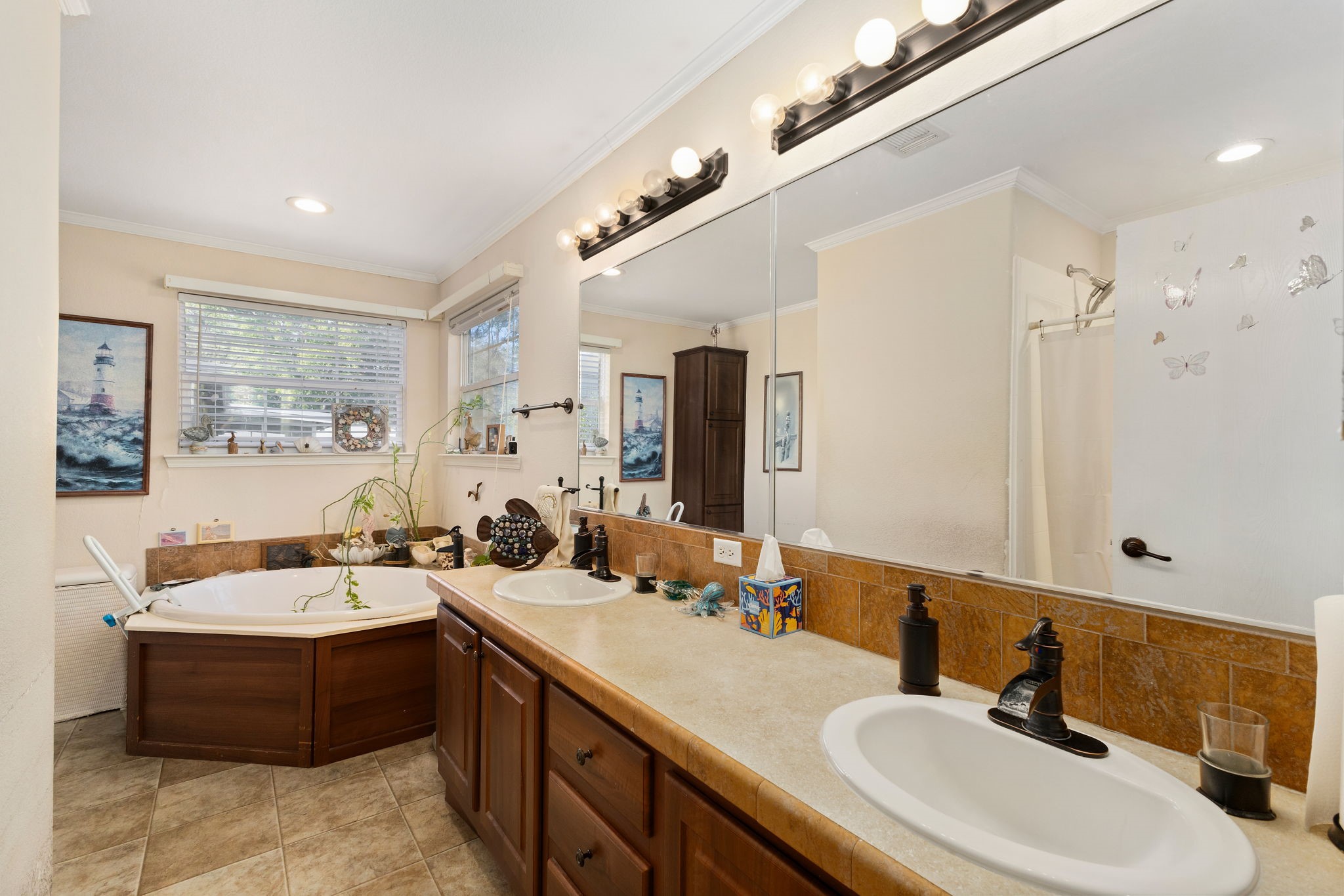 8103 Adamek Road Brenham, TX 77833 - Photo 25 of 42 a large bathroom with a double vanity sink a mirror and a bathtub