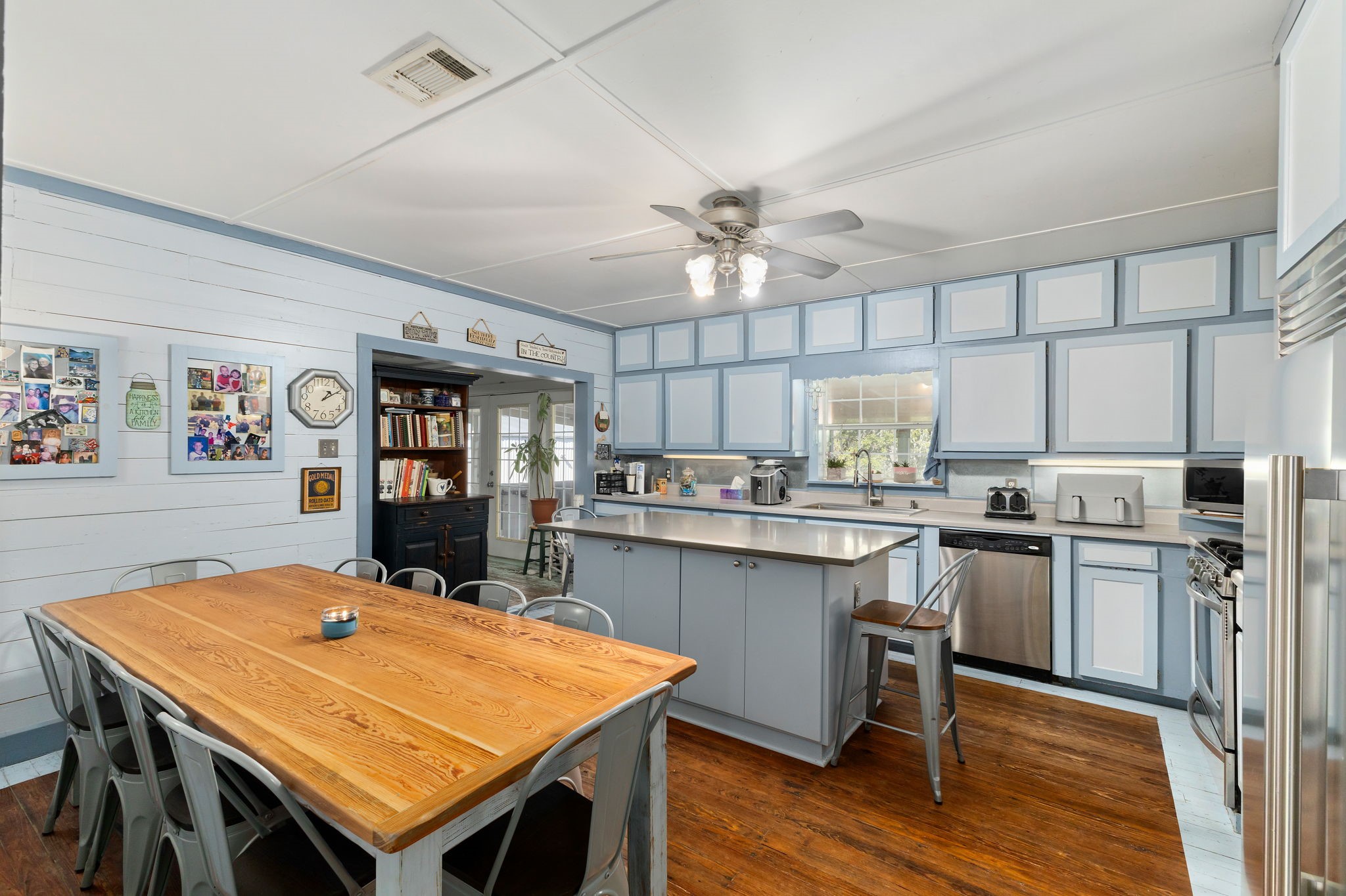 8103 Adamek Road Brenham, TX 77833 - Photo 5 of 42 a kitchen with stainless steel appliances granite countertop a kitchen island a stove a table and chairs in it