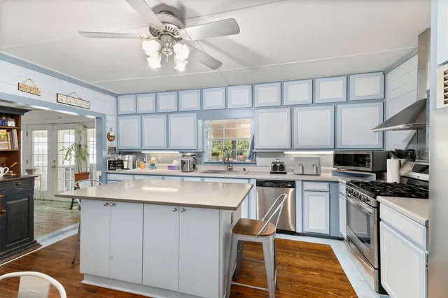 a kitchen with stainless steel appliances granite countertop a kitchen island a stove a table and chairs in it