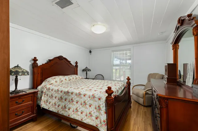 a kitchen with stainless steel appliances granite countertop a stove top oven a refrigerator a dining table and chairs with wooden floor