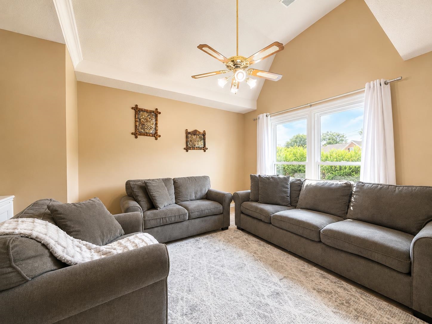 326 South Sanga Road Cordova, TN 38018 - Photo 11 of 32 Living area featuring a vaulted ceiling with crown molding, a ceiling fan with integrated lighting, and light-toned walls