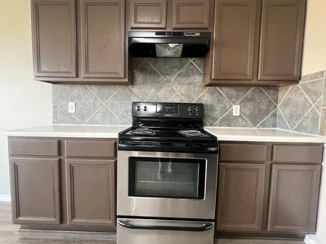 a stove top oven sitting inside of a kitchen