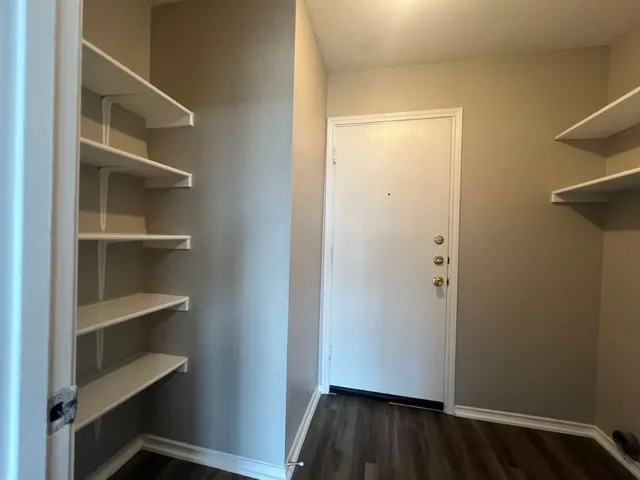 a view of walk in closet with empty racks
