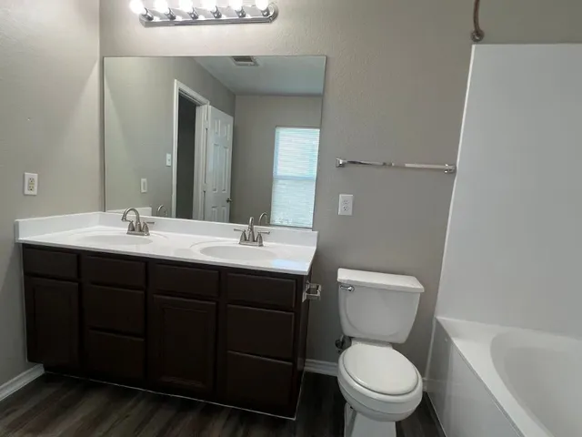 a bathroom with a toilet a sink and mirror