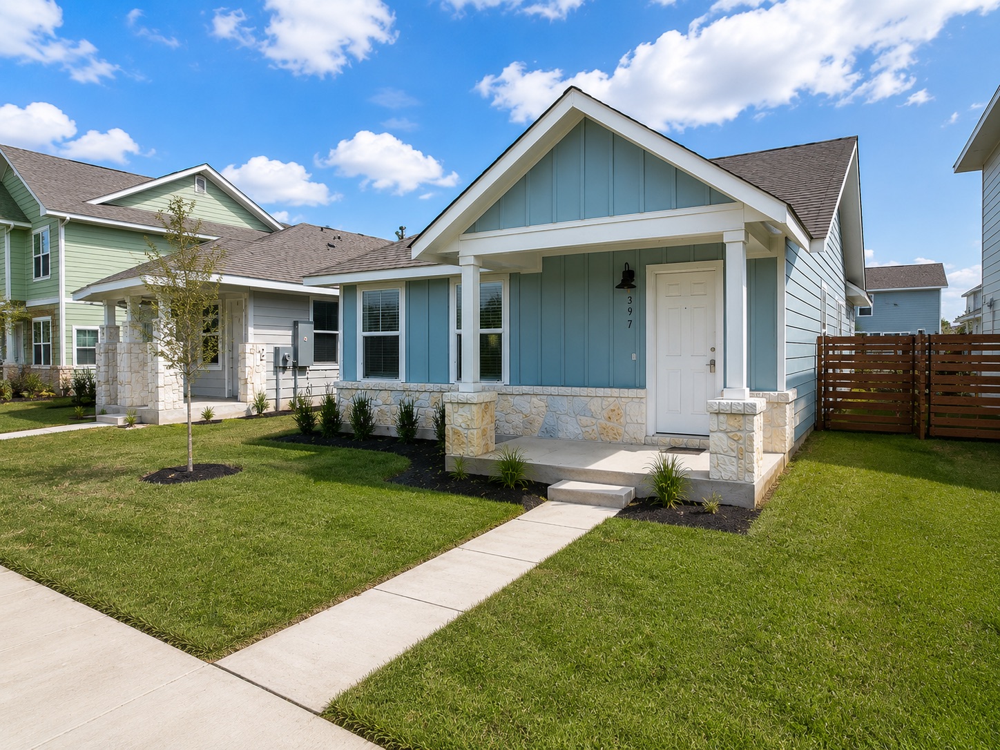 397 Keefer Kyle, TX 78640 - Photo 2 of 33 A welcoming facade with a covered porch and stone accents, set amidst lush green landscaping.