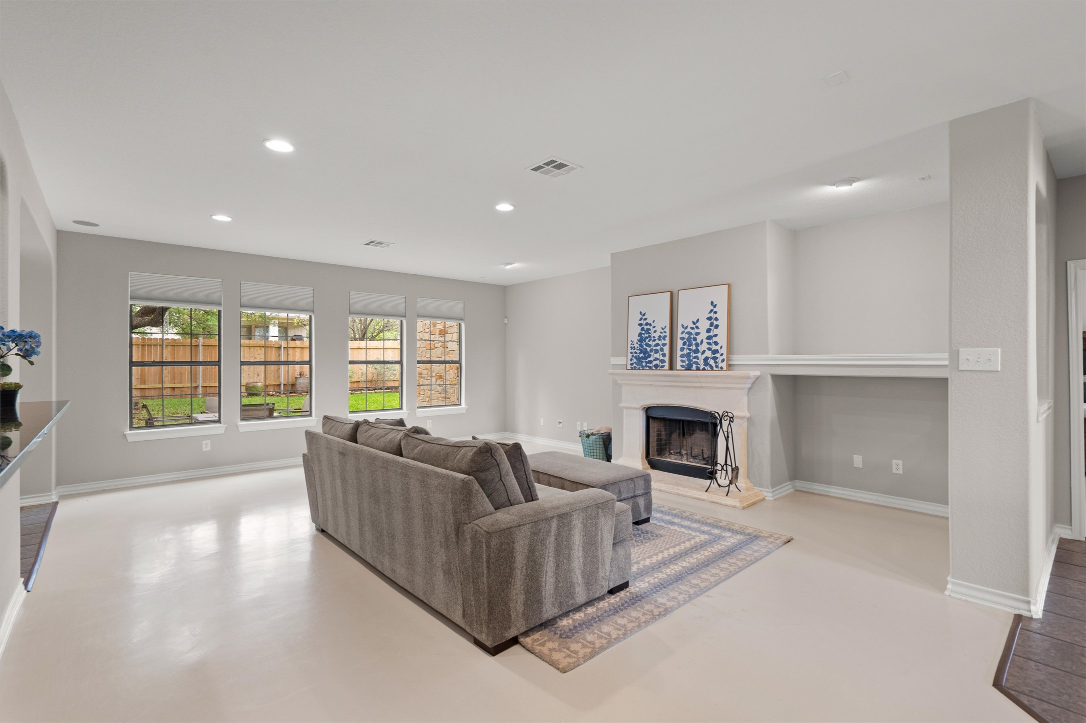 101 Breakaway Road Cedar Park, TX 78613 - Photo 9 of 37 Living room with recessed lighting, a fireplace with raised hearth, and concrete flooring