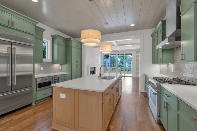 a kitchen with stainless steel appliances granite countertop a sink a stove and a refrigerator