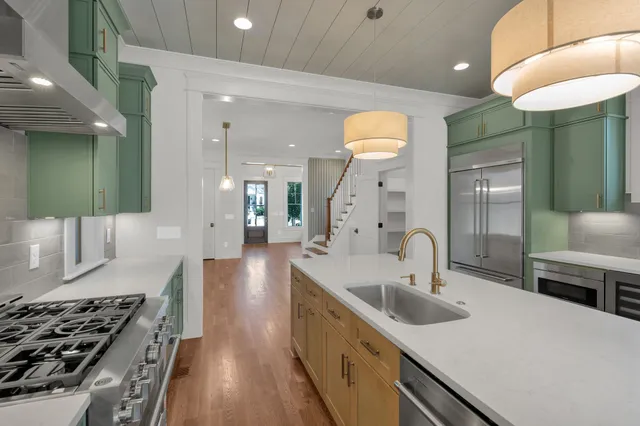 a kitchen with stainless steel appliances a sink stove and cabinets