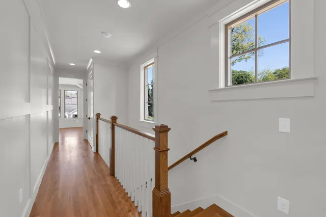 a view of a hallway with wooden floor and staircase