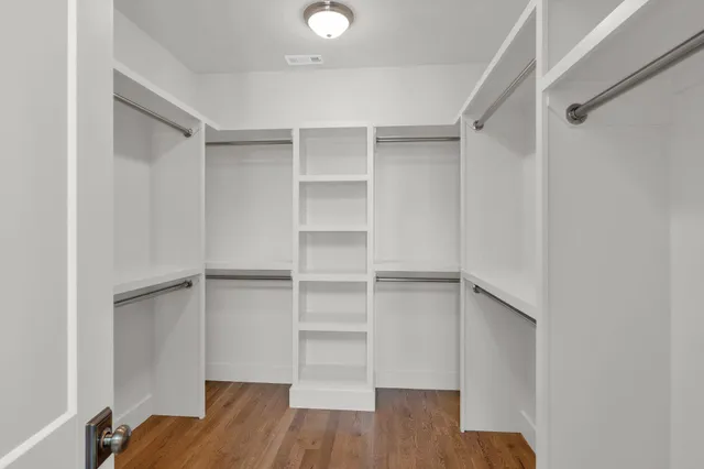 a view of walk in closet with empty racks