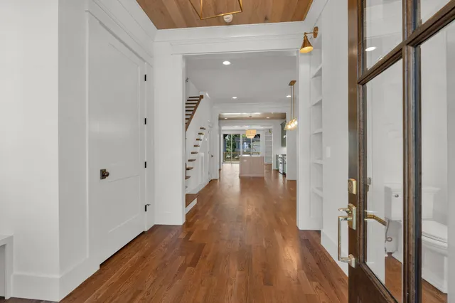 a view of a hallway with wooden floor and staircase