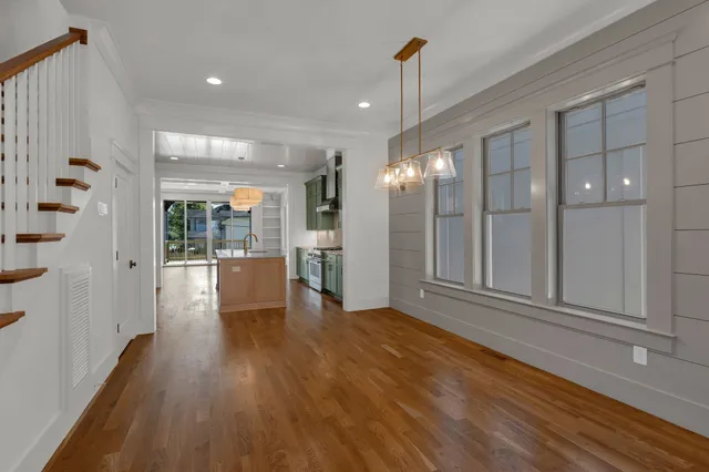 a view of a big room with wooden floor and windows