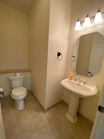 a bathroom with a double vanity sink toilet and a mirror
