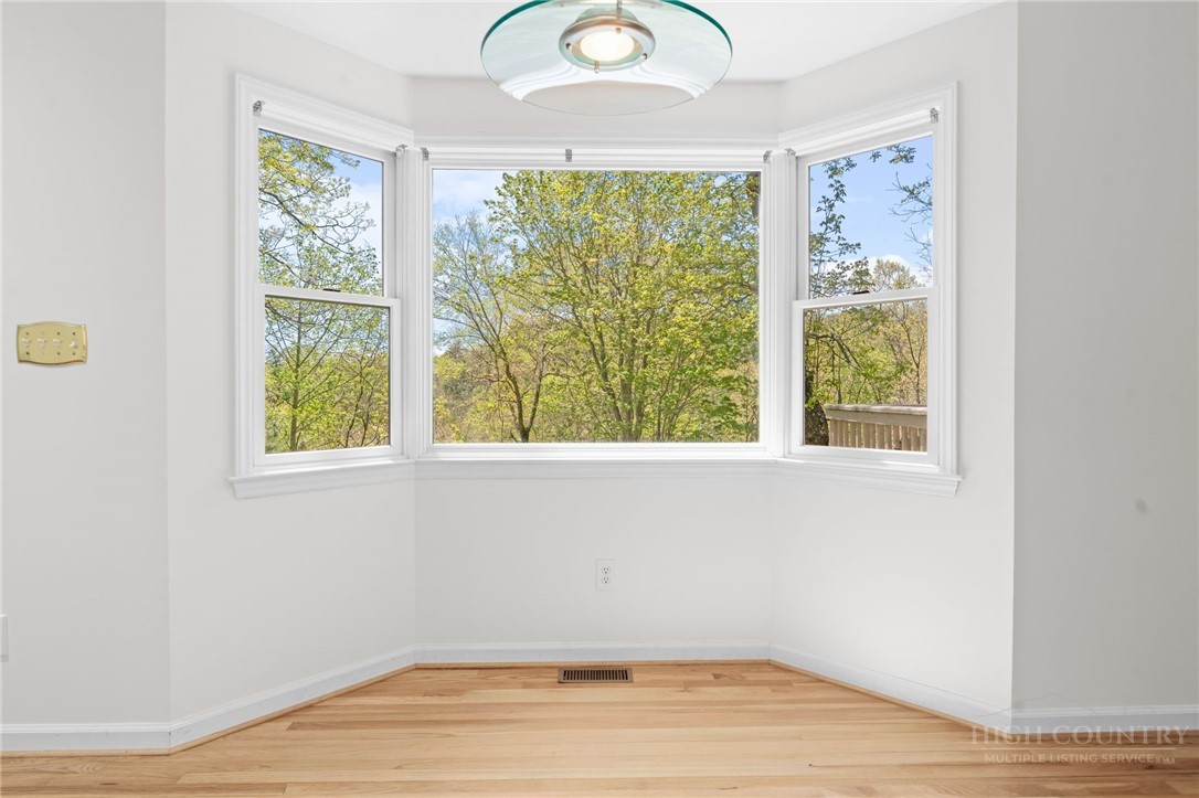 480 North Ridge Circle Boone, NC 28607 - Photo 15 of 50 an empty room with wooden floor and windows