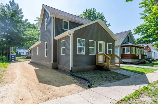 a front view of a house with a yard outdoor seating and barbeque oven