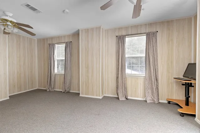 a view of empty room with windows and wardrobe