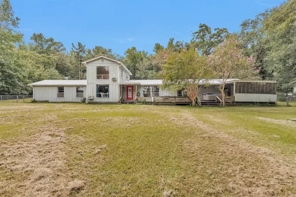 a view of a house with a big yard and large trees