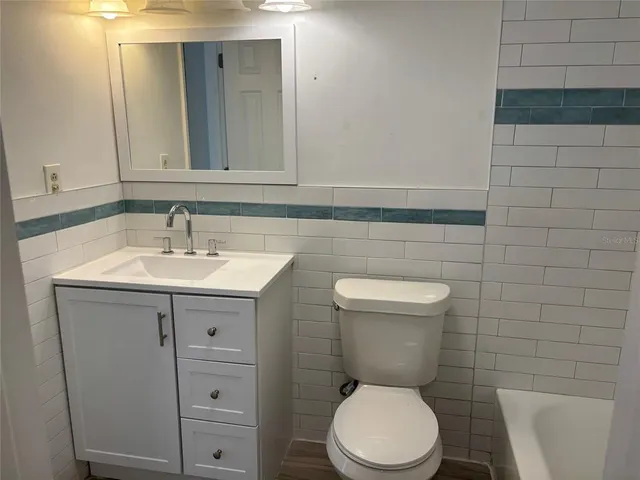 a bathroom with a sink a toilet and mirror