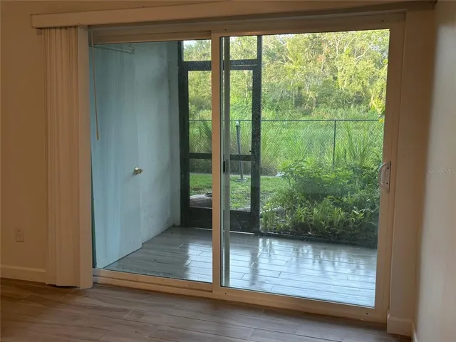 a view of a room with wooden floor and a window