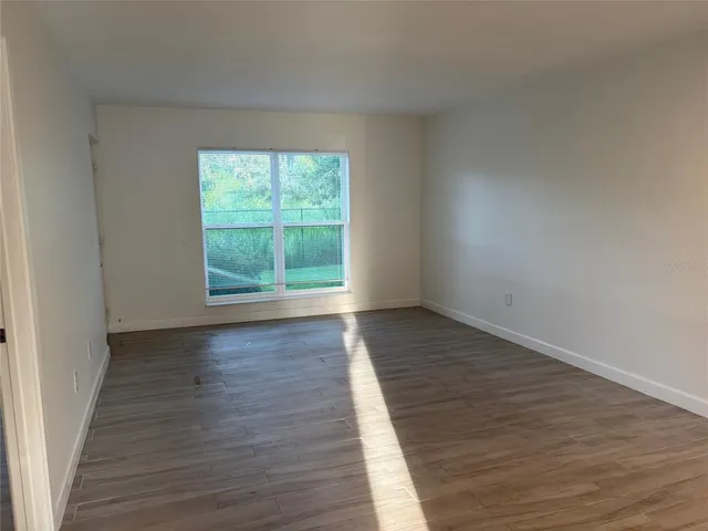 a view of an empty room with wooden floor