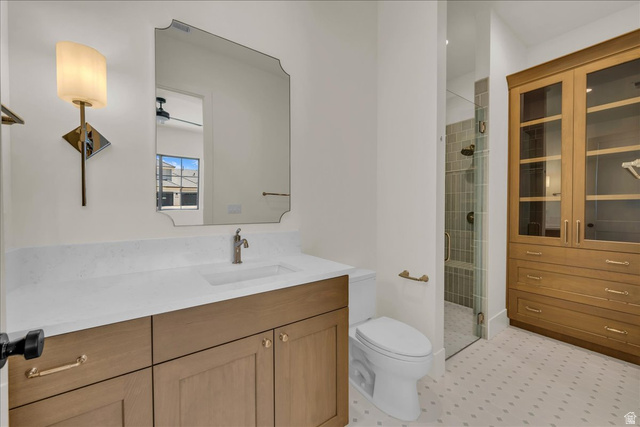 1620 Belayer Drive St. George, UT 84770 - Photo 17 of 51 Bathroom featuring a wood-finish vanity with a light-toned countertop and integrated sink, a framed mirror, and a wall-mounted light fixture