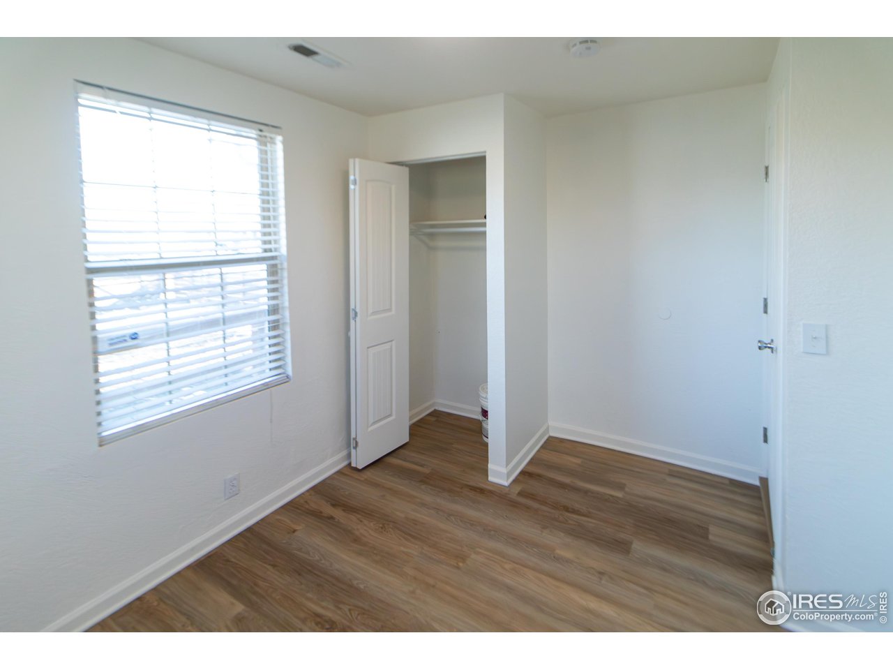 927 South Yates Street, Unit A Denver, CO 80219 - Photo 7 of 13 a view of an empty room with wooden floor and a window