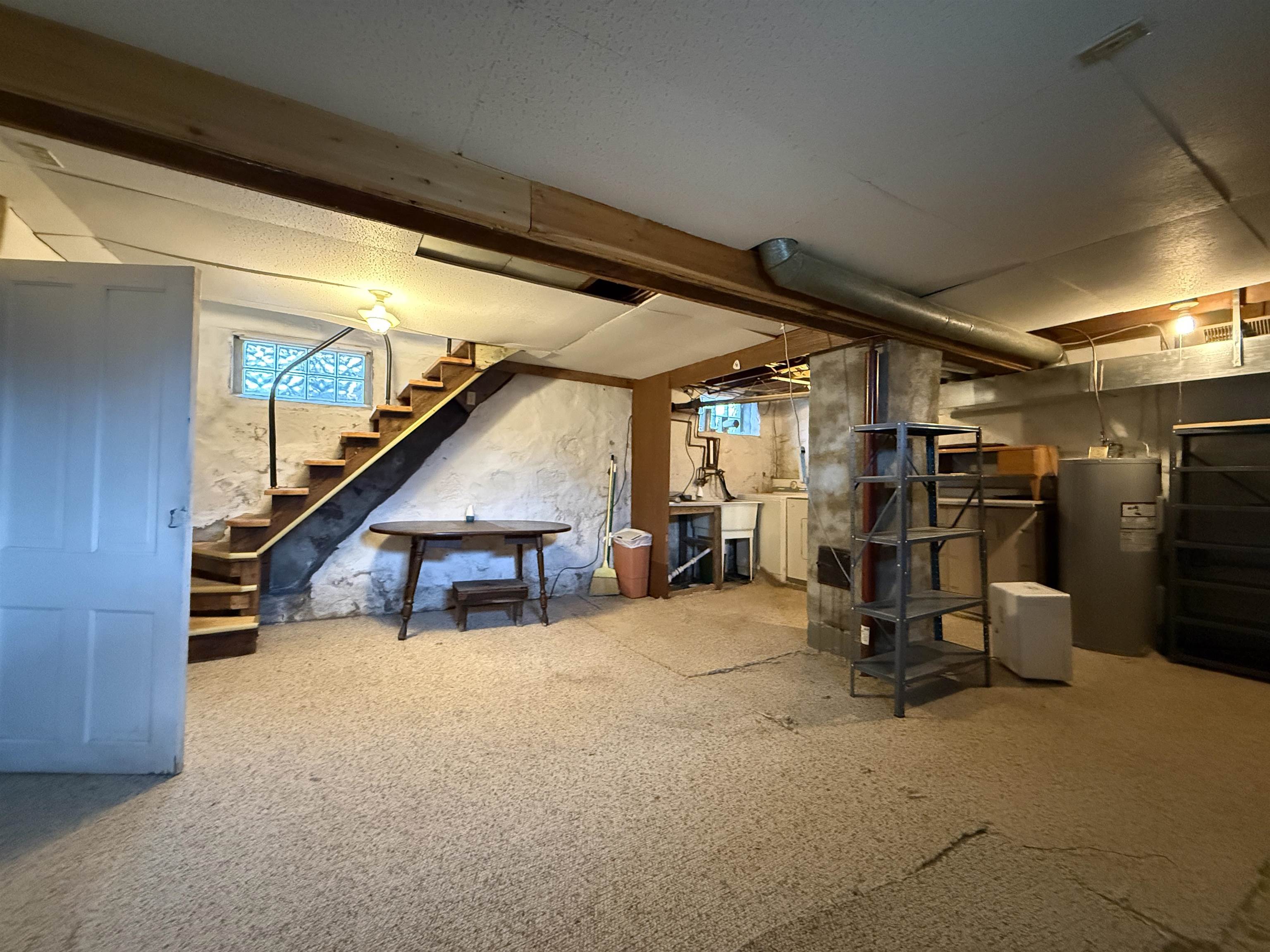 214 8th Street Southwest Chisholm, MN 55719 - Photo 24 of 25 Below grade area featuring stairs, electric water heater, and healthy amount of natural light