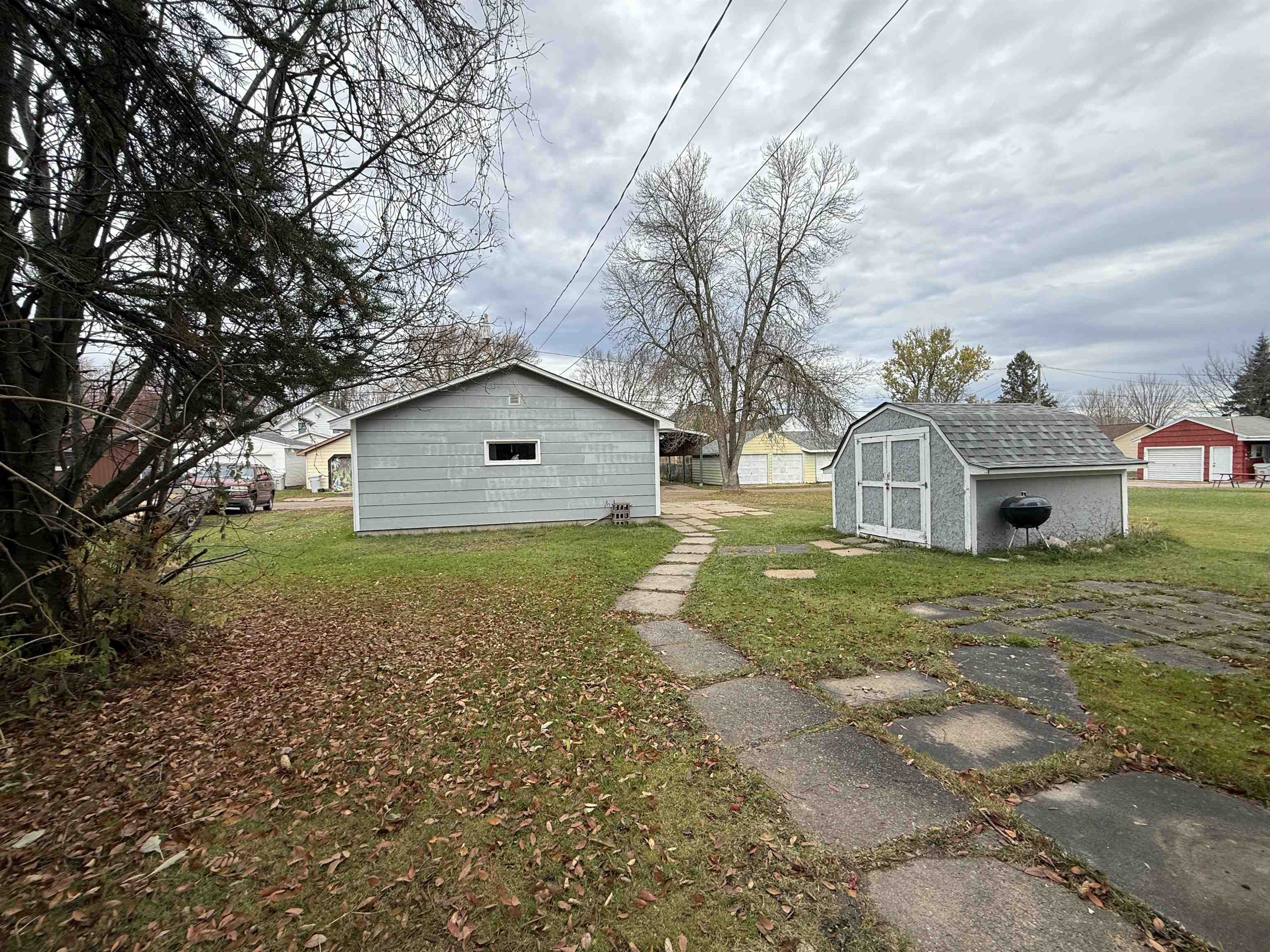214 8th Street Southwest Chisholm, MN 55719 - Photo 7 of 25 View of home's exterior featuring a yard and a storage shed