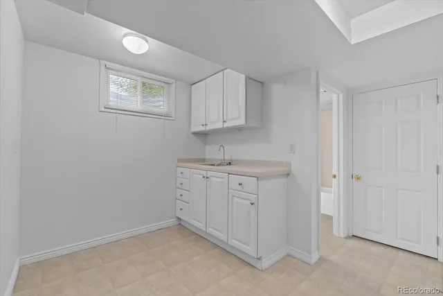 a room with white cabinets and sink